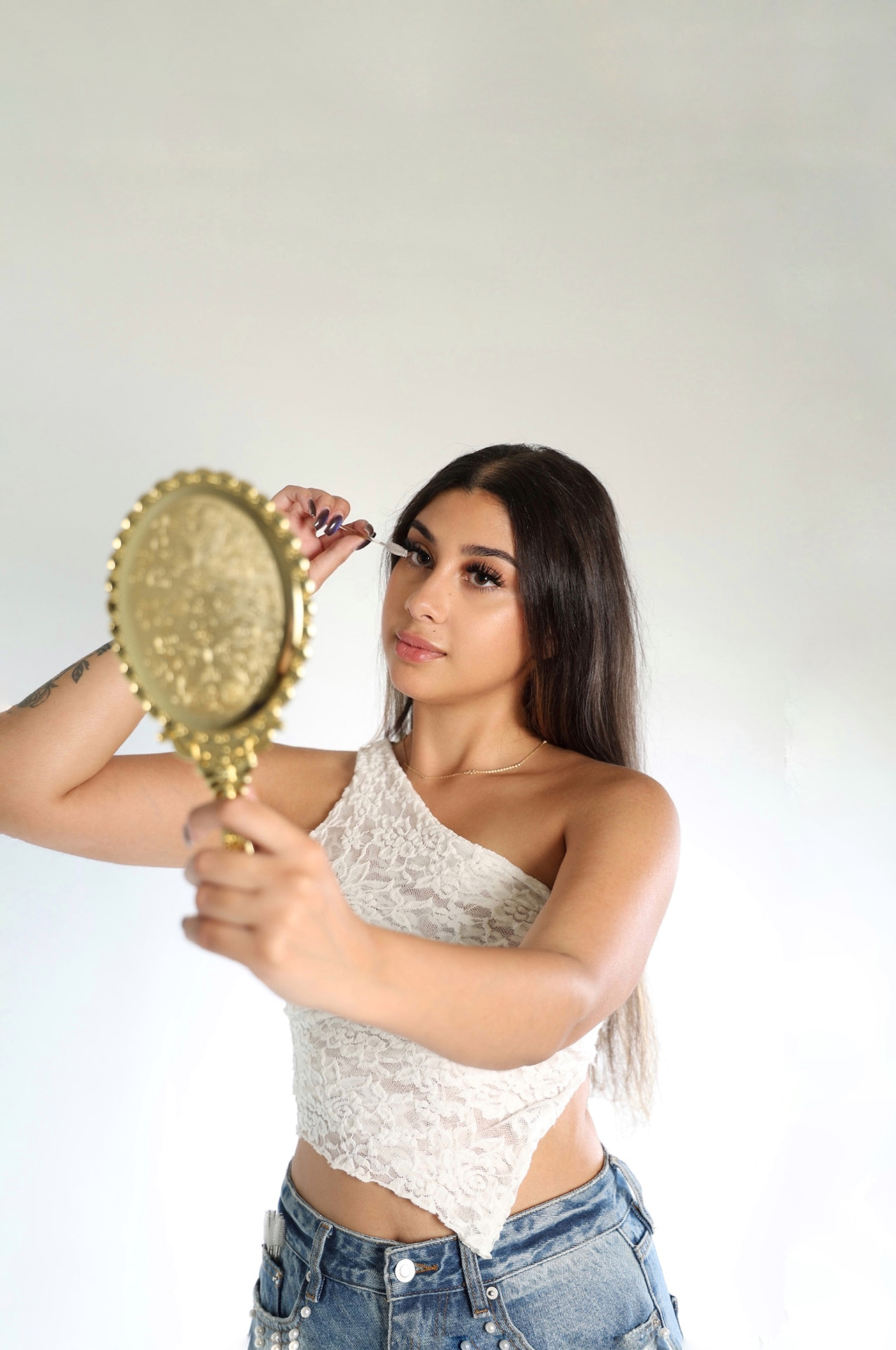 Jen, founder of Soft Esthetics, holding a gold mirror